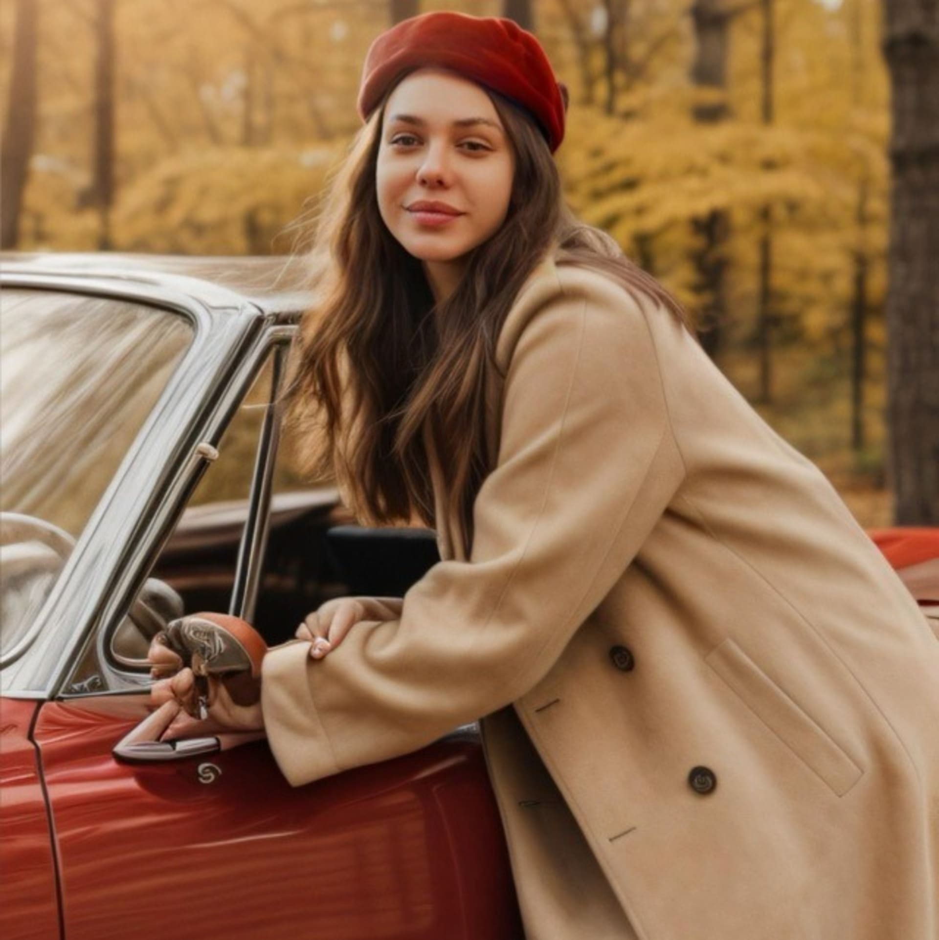 A woman in a red beret and beige coat leans on the open door of a red car in an autumn forest setting.
